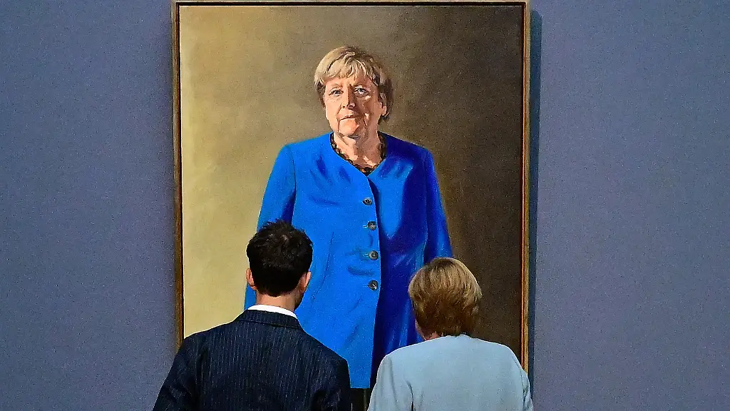 Former-German-chancellor-Angela-Merkel-R-and-French-German-artist-Jeremie-Queyras-L-look-at-his-painting-Portrait-of-former-Federal-Chancellor-Angela-Merkel-after-it-was-unveiled-at-the-Bode-Museum-in-Berlin-on-June-30-2026