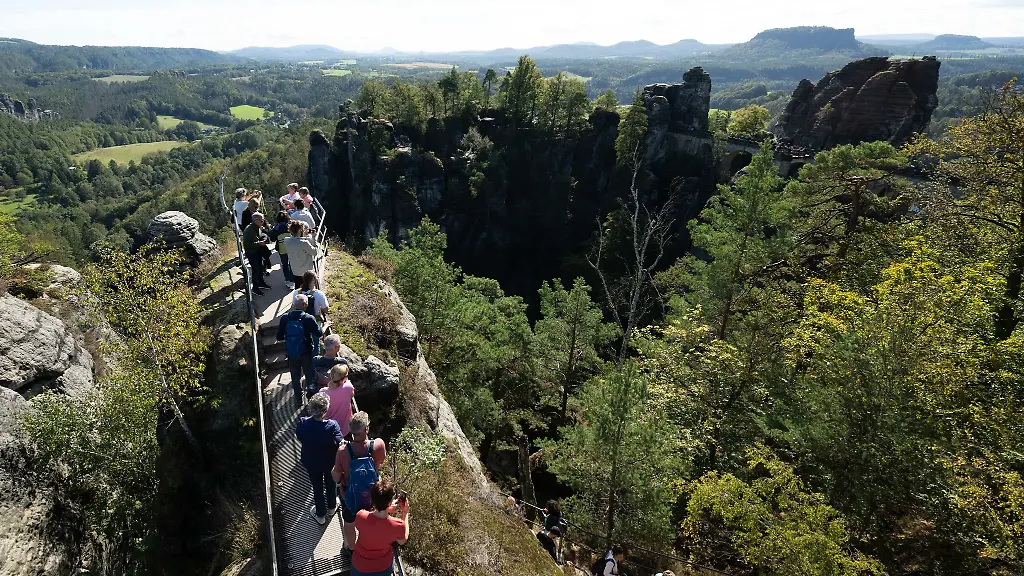 Touristen-geniessen-die-Felsenlandschaft-der-Saechsischen-Schweiz-Die-Tourismusbranche-spricht-von-einer-insgesamt-guten-Buchungslage-in-der-aktuellen-Sommersaison