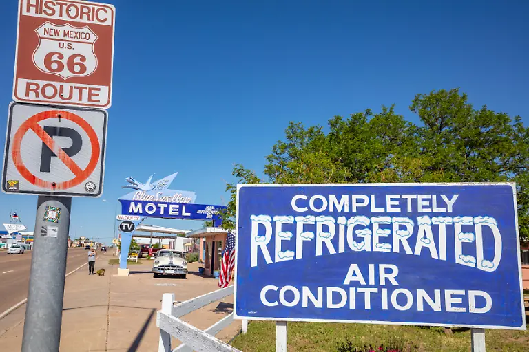 Tucumcari-New-Mexico-USA-May-14-2019-Motel-Blue-Swallow-next-to-route-66-A-pontiac-car-is-parked-at-the-entrance-Signs-inform-tourists-about-the-accommodation