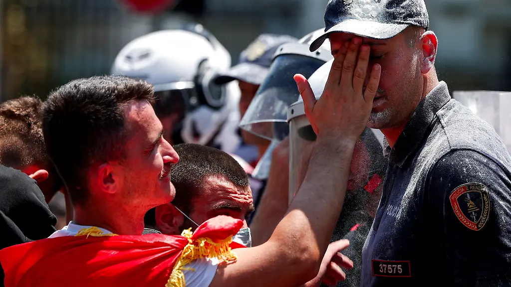 A-man-helps-a-police-officer-clean-his-face-during-a-demonstration-against-the-government-following-weeks-of-protests-against-a-planned-luxury-resort-backed-by-a-company-linked-to-Jared-Kushner-the-son-in-law-of-U-S-President-Donald-Trump-on-an-environmentally-sensitive-part-of-the-Adriatic-coast-in-Tirana-Albania-July-2-2026