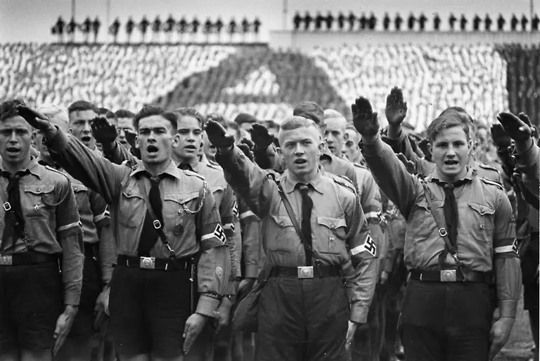 Reichsparteitag-1938-HJ-beim-Hitlergruss-10-Reichsparteitag-der-NSDAP-Parteitag-Grossdeutschland-Nuernberg-5-12-Sep-tember-1938-Aufmarsch-der-Hitlerjugend-HJ-u-BdM-vor-Hitler-im-Stadion-von-Nuernberg-10-September-1938-die-angetretene-HJ-Formation-hebt-die-Hand-zum-Hitlergruss-Foto