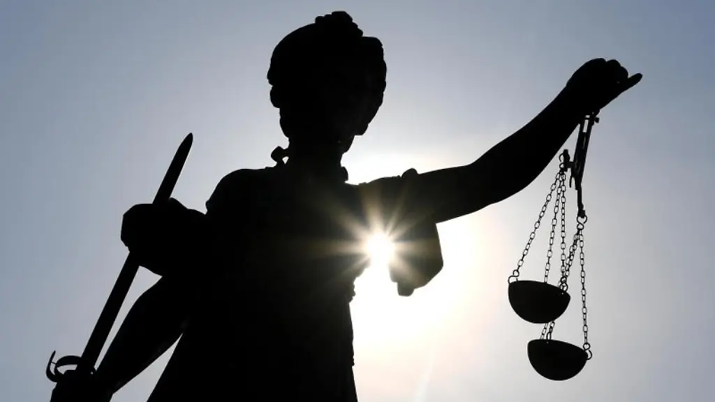 Die-Statue-der-Justitia-steht-im-Gegenlicht-der-Sonne