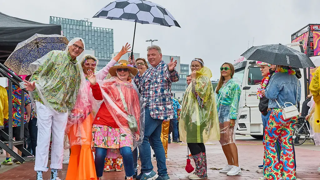 Mit-Capes-und-Regenschirmen-schuetzen-sich-die-Schlagerfans-beim-Schlagermove-vor-dem-Hamburger-Schietwetter