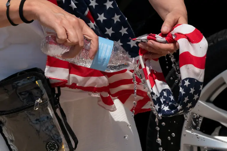 A-woman-drenches-a-scarf-in-water-during-extreme-heat-near-the-U-S-Capitol-during-Salute-to-America-marking-the-250th-anniversary-of-U-S-Independence-in-Washington-D-C-U-S-July-4-2026