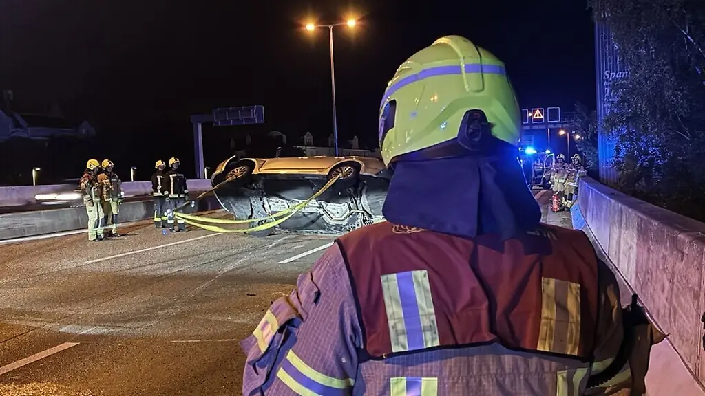 Die-Berliner-Feuerwehr-richtet-ein-Auto-auf-das-sich-auf-der-Stadtautobahn-A100-ueberschlagen-hat