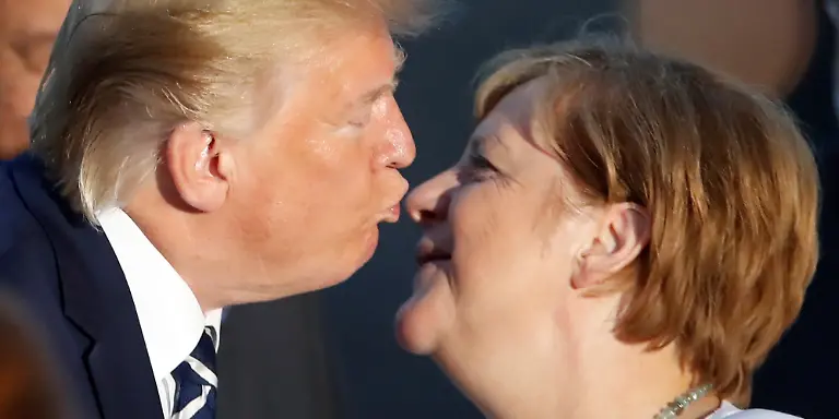 Donald-Trump-Praesident-der-USA-kuesst-Bundeskanzlerin-Angela-Merkel-CDU-zur-Begruessung-beim-gemeinsamen-Familienfoto-im-Rahmen-des-G7-Gipfels-Der-G7-Gipfel-findet-vom-24-26-August-in-Biarritz-statt