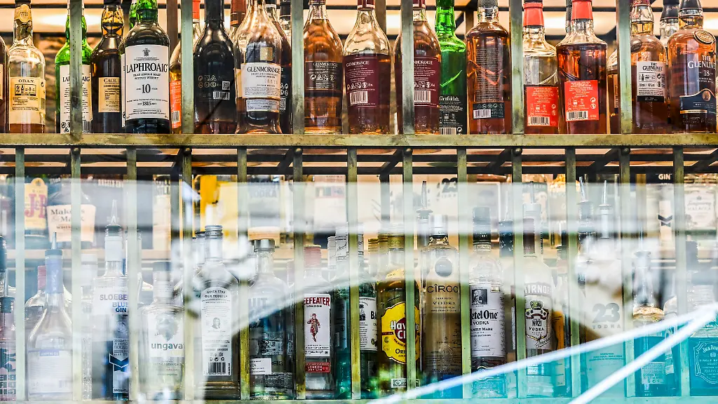ARCHIV-06-07-2023-Berlin-Flaschen-mit-verschieden-Sorten-Alkohol-sind-hinter-Fensterscheiben-einer-Bar-zu-sehen