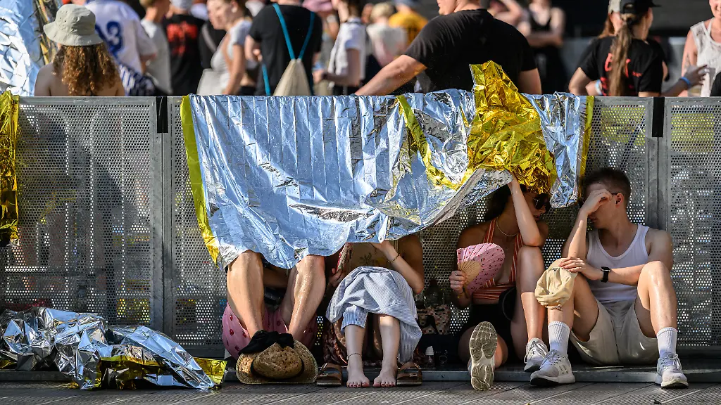 Fans-der-Band-Kraftklub-schuetzen-sich-vor-Beginn-des-Konzerts-im-Rahmen-der-Sterben-in-Karl-Marx-Stadt-Open-Airs-2026-im-Rudolf-Harbig-Stadion-unter-Rettungsfolien-vor-der-Sonne
