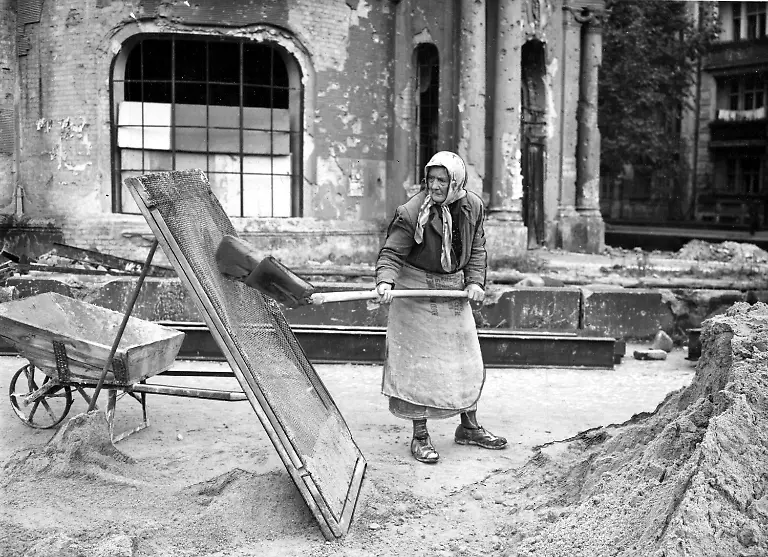 One-of-the-many-thousand-so-called-rubble-women-Truemmerfrauen-cleans-sand-in-the-totally-bombed-out-Berlin-Germany-December-22-1948