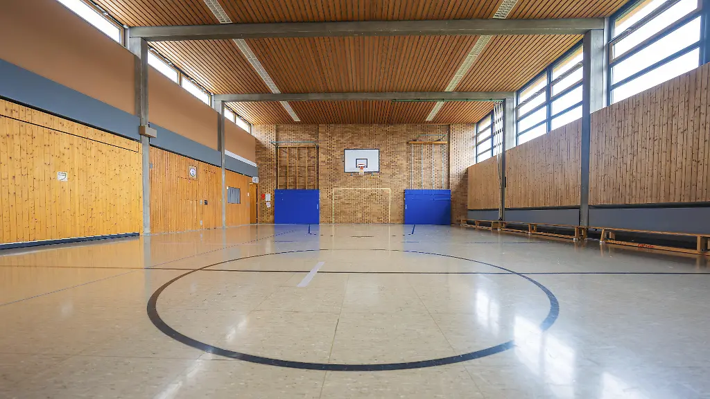 Leere-Sporthalle-mit-Holzvertaefelung-und-Basketballkorb-beleuchtet-durch-grosse-Fenster-Schlehengaeu-Grund-Schule-Gechingen-Landkreis-Calw-Deutschland