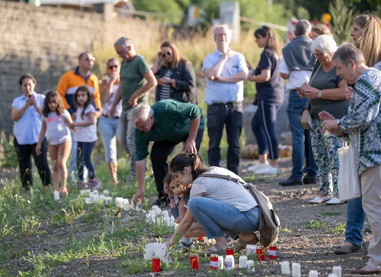 Zum-Gedenken-an-die-Opfer-der-Flutkatastrophe-entzuenden-Menschen-am-Ufer-der-Ahr-in-Schuld-Kerzen-Schuld-war-von-den-Wassermassen-extrem-stark-zerstoert-worden