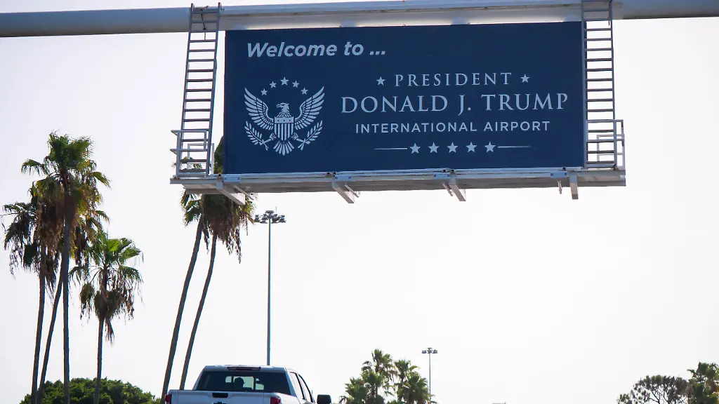 Autos-fahren-unter-einem-neuen-Schild-mit-der-Aufschrift-President-Donald-J-Trump-International-Airport-auf-die-Einfahrt-zum-Flughafen-zu