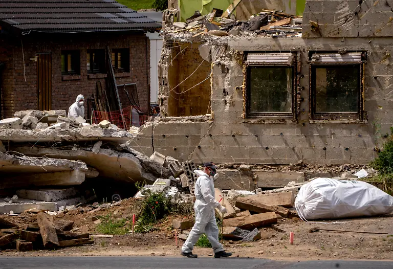 A-worker-walks-by-a-home-damaged-from-last-year-s-floods-that-is-now-torn-down-in-the-village-of-Ahrbrueck-in-the-Ahrtal-valley-Germany-Wednesday-July-6-2022-Flooding-caused-by-heavy-rain-hit-the-region-on-July-14-2021-causing-the-death-of-about-130-people