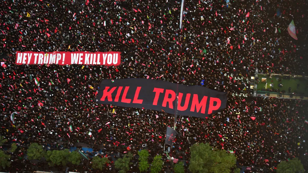 Mashhad-Iran-July-9-2026-Participants-seen-holding-a-banner-bearing-the-English-language-message-We-will-kill-Trump-Thousands-of-people-gather-on-Imam-Reza-Boulevard-for-a-final-farewell-to-Ayatollah-Khamenei-as-his-coffin-is-carried-toward-the-Imam-Reza-Shrine-Many-mourners-wave-red-flags-which-participants-say-symbolize-a-call-for-revenge-against-those-they-hold-responsible-for-his-death-alongside-other-religious-flags-associated-with-the-Shia-community-The-procession-draws-large-crowds-lining-the-route-leading-to-the-shrine-FARNOOD-sipa