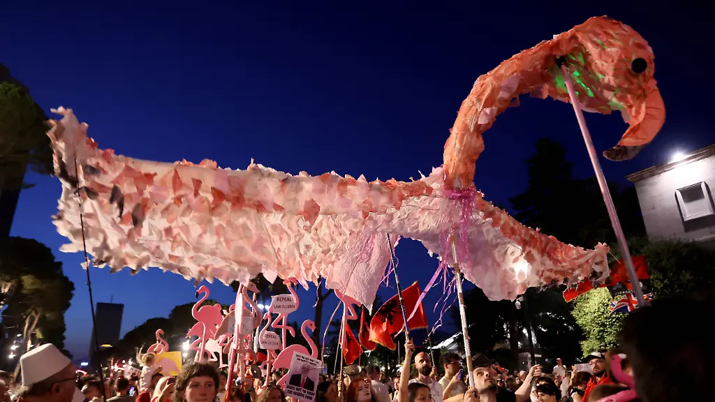 July-11-2026-Tirana-Albania-ALB-Protesters-hold-signs-and-Albanian-national-flags-as-they-take-part-in-a-demonstration-in-front-of-the-PM-office-in-Tirana-opposing-the-construction-of-a-luxury-resort-in-a-protected-natural-area-near-the-city-of-Vlore-Several-thousand-citizens-demonstrated-in-Tirana-for-the-42nd-consecutive-night-to-demand-transparency-on-a-luxury-tourism-complex-project-in-the-protected-area-of-Narta-Lagoon-in-the-city-of-Vlore-linked-to-US-President-Donald-Trump-s-son-in-law-Jared-Kushner-and-his-wife-Ivanka-Trump-The-project-was-planned-for-two-areas-along-the-Adriatic-coast-the-protected-delta-area-of-Vjosa-Narta-and-the-nearby-uninhabited-island-of-Sazan