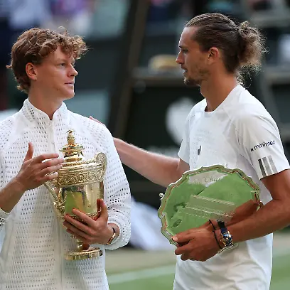 Tennis-Wimbledon-All-England-Lawn-Tennis-and-Croquet-Club-London-Britain-July-12-2026-Italy-s-Jannik-Sinner-celebrates-with-the-trophy-as-Germany-s-Alexander-Zverev-celebrates-with-the-runner-up-trophy-after-their-final-match-REUTERS-Toby-Melville