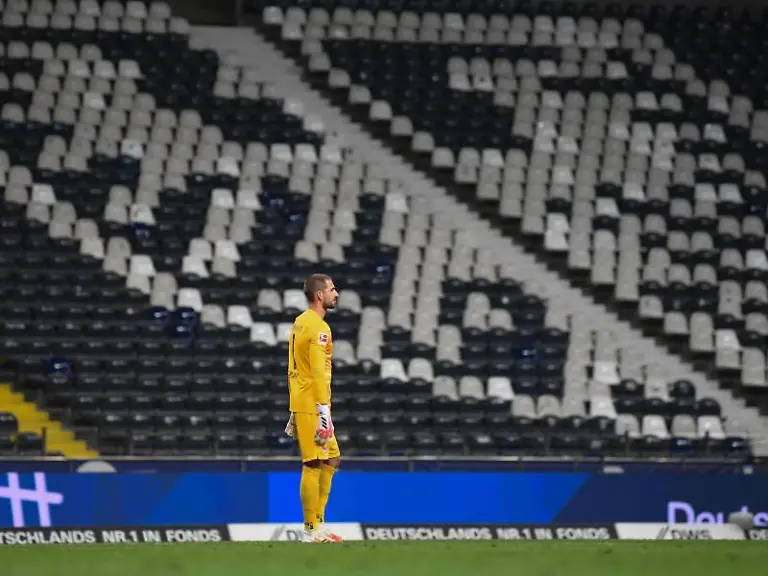 Torwart-Kevin-Trapp-aus-Frankfurt-steht-vor-der-leeren-Tribuene-mit-dem-Eintracht-Adler