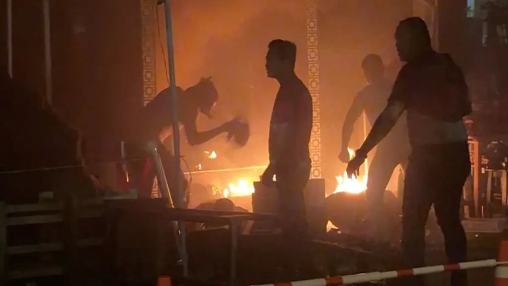 People-try-to-douse-a-fire-following-a-deadly-fire-at-a-pub-in-Bangkok-Thailand-July-12-2026-in-this-screengrab-obtained-from-a-video-VIDEO-OBTAINED-BY-REUTERS-Handout-via-REUTERS-THIS-IMAGE-HAS-BEEN-SUPPLIED-BY-A-THIRD-PARTY-VERIFICATION-Reuters-verified-the-location-from-the-buildings-highway-and-trees-seen-in-the-video-which-matched-archive-and-satellite-imagery-of-the-area-The-date-when-the-video-was-recorded-was-verified-by-the-metadata-on-the-original-video-files