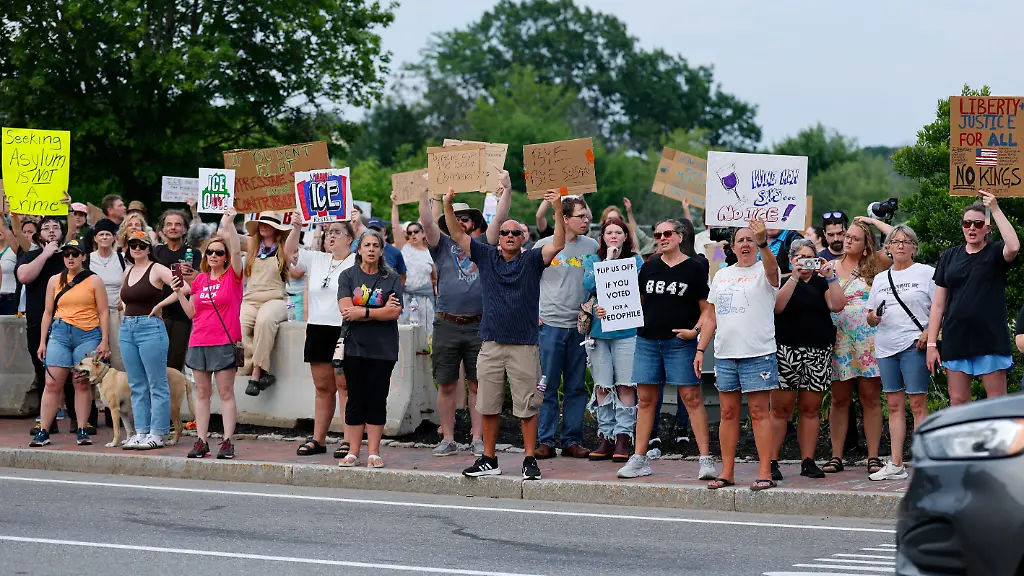 People-hold-signs-as-they-protest-against-U-S-Immigration-and-Customs-Enforcement-ICE-at-Mechanics-Park-after-a-shooting-involving-ICE-in-Biddeford-Maine-U-S-July-13-2026