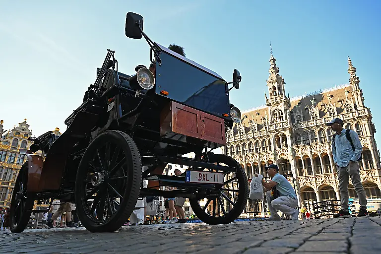 Eine-E-Kutsche-steht-auf-dem-Grand-Place-Grote-Markt-im-Zentrum-von-Bruessel-Nach-anhaltender-Kritik-an-der-Nutzung-von-Pferden-fuer-touristische-Zwecke-fuehrte-die-belgische-Hauptstadt-2024-elektrische-Kutschen-ein-Die-bei-Touristen-beliebte-Millionenstadt-galt-mit-dem-Projekt-als-Vorreiter