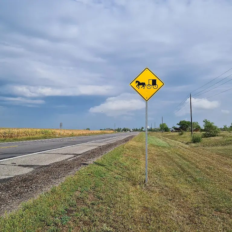 An-einer-Landstrasse-nahe-der-Kleinstadt-Long-Prairie-steht-ein-Schild-das-auf-Pferdekutschen-aufmerksam-macht-In-diesen-Kutschen-sind-Familien-der-Amische-unterwegs-Die-taeuferisch-protestantische-Glaubensgemeinschaft-hat-ihre-Wurzeln-in-der-Schweiz-und-Sueddeutschland-Im-US-Bundestaat-Minnesota-leben-die-Amische-vor-allem-von-der-Landwirtschaft-Sie-lehnen-moderne-Techniken-wie-beispielsweise-Smartphones-und-Autos-ab