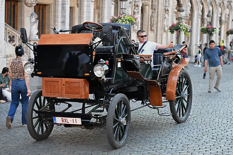 Ein-Tourist-sitzt-in-einer-E-Kutsche-auf-dem-Grand-Place-Grote-Markt-im-Zentrum-von-Bruessel-Nach-anhaltender-Kritik-an-der-Nutzung-von-Pferden-fuer-touristische-Zwecke-fuehrte-die-belgische-Hauptstadt-2024-elektrische-Kutschen-ein-Die-bei-Touristen-beliebte-Millionenstadt-galt-mit-dem-Projekt-als-Vorreiter