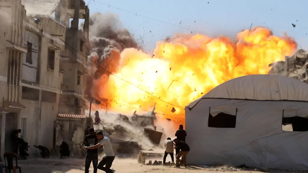 Palestinians-attempt-to-take-cover-from-a-massive-explosion-following-an-Israeli-airstrike-targeting-a-blacksmith-workshop-in-the-al-Sabra-neighborhood-of-Gaza-City-on-July-12-2026