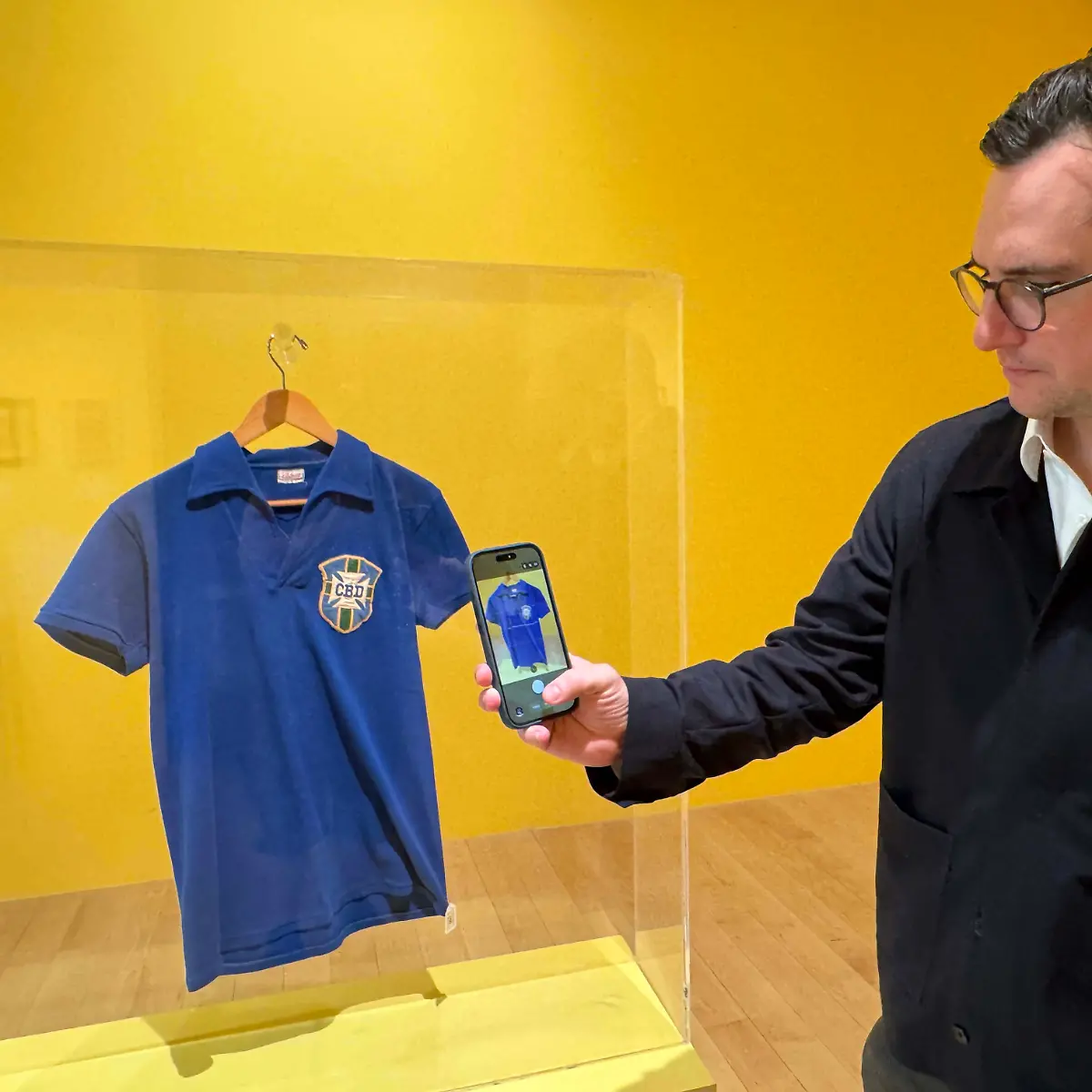 July-1-2026-New-York-New-York-USA-BRENDAN-HAWKES-VP-Sports-Strategy-and-Development-takes-a-cellphone-photo-of-the-Pele-1958-FIFA-World-Cup-Final-Championship-Clinching-Match-Worn-Shirt-estimate-over-1-million-seen-during-The-Beautiful-Game-Sports-Week-Auction-at-Sotheby-s-New-York-Presents-The-Summer-Season-at-the-Breuer