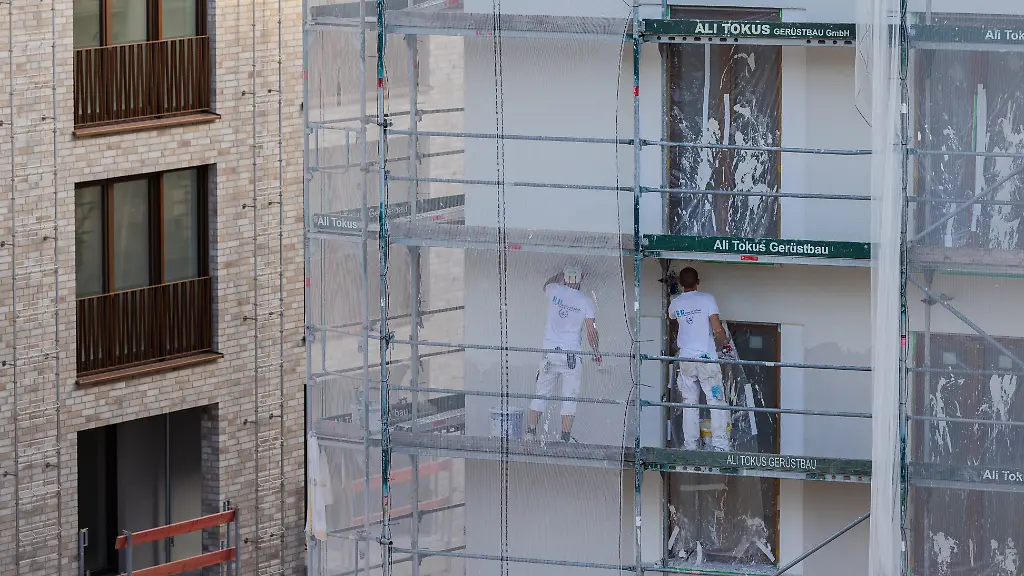 Arbeiter-verputzen-ein-Haus-mit-Eigentumswohnungen-Die-Zahl-der-Baugenehmigungen-ist-leicht-angestiegen-Die-Zahl-der-neuen-Wohnungen-in-Nordrhein-Westfalen-ist-auf-dem-niedrigsten-Stand-seit-2011