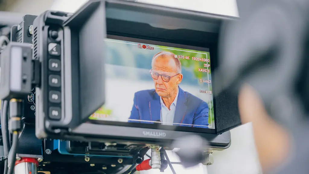 Auf-diesem-vom-ZDF-zur-Verfuegung-gestellten-Handout-ist-Bundeskanzler-Friedrich-Merz-CDU-im-Sucher-einer-Fernsehkamera-zu-sehen-beim-ZDF-Sommerinterview-2026-in-Meschede