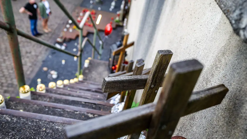 Auf-der-Treppe-am-Ungluecksort-stehen-21-Holzkreuze-fuer-jede-verstorbene-Person-ein-Kreuz