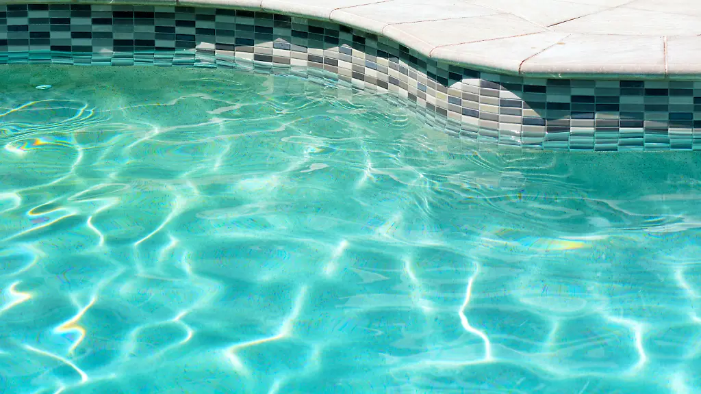 Swimming-pool-with-clear-turquoise-color-An-edge-of-outdoor-swimming-pool-with-clear-turquoise-color-water-and-sunny-reflections