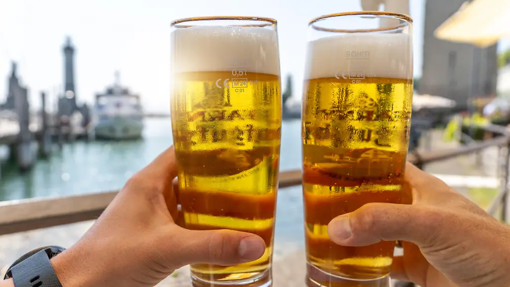 Prost-am-Wasser-im-Urlaub-zwei-kuehle-Bierglaeser-im-Sommerlicht