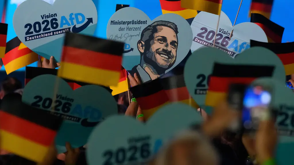 Teilnehmer-warten-auf-den-Beginn-des-Wahlkampfauftakts-der-AfD-Sachsen-Anhalt-und-schwenken-Deutschlandfahnen-und-halten-Herzen-mit-dem-Portraet-des-Spitzenkandidaten-hoch-Die-Landtagswahl-in-Sachsen-Anhalt-findet-am-06-September-2026-statt