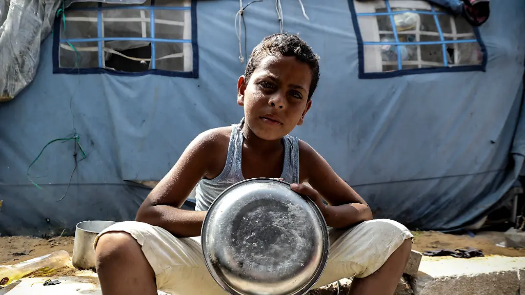 A-Palestinian-boy-holds-an-empty-cooking-pot-at-a-displacement-camp-in-the-Gaza-Strip-on-May-20-2026-Palestinians-in-Gaza-are-preparing-for-Eid-al-Adha-amid-worsening-humanitarian-conditions-and-food-shortages-caused-by-the-ongoing-war-with-many-families-unable-to-afford-traditional-holiday-meals-or-sacrificial-animals