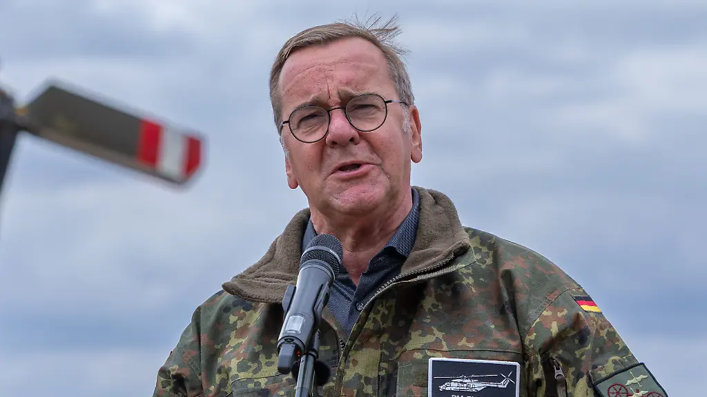 Bundesverteidigungsminister-Boris-Pistorius-spricht-vor-einem-Mikrofon-gekleidet-in-Bundeswehr-Flecktarn-Jacke-mit-Namensschild-BM-Pistorius-Sein-Gesichtsausdruck-wirkt-ernst-und-konzentriert-der-Blick-leicht-zusammengezogen-der-Eindruck-ist-Bundesminister-Boris-Pistorius-besucht-Transporthubschrauberregiment-30-Kuelsheim-23-07