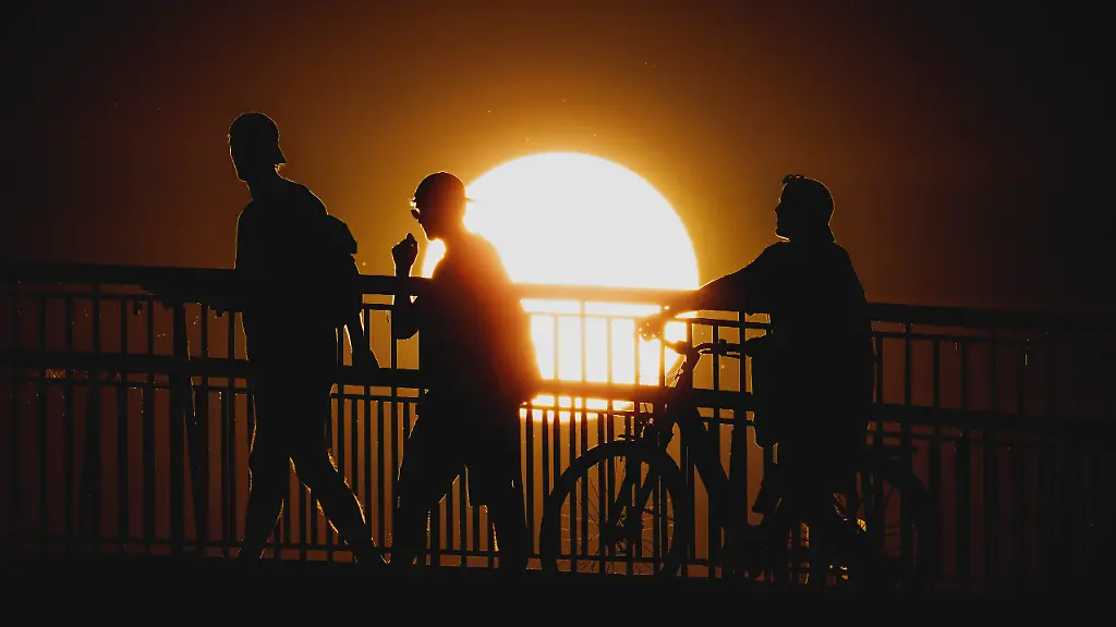 Personen-zeichnen-sich-als-Silhouette-ab-vor-der-untergehenden-Sonne-in-Berlin-19-06-2026-In-ganz-Deutschland-herrscht-aktuell-eine-Hitzewelle