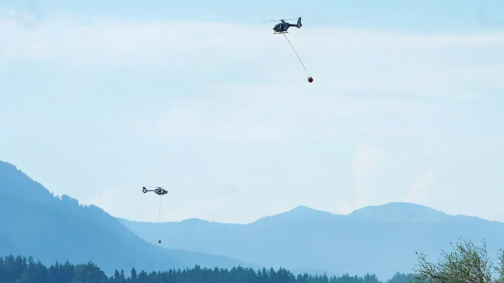Hubschrauber-bringen-Loeschwasser-zu-einem-Wald-und-Moorbrand