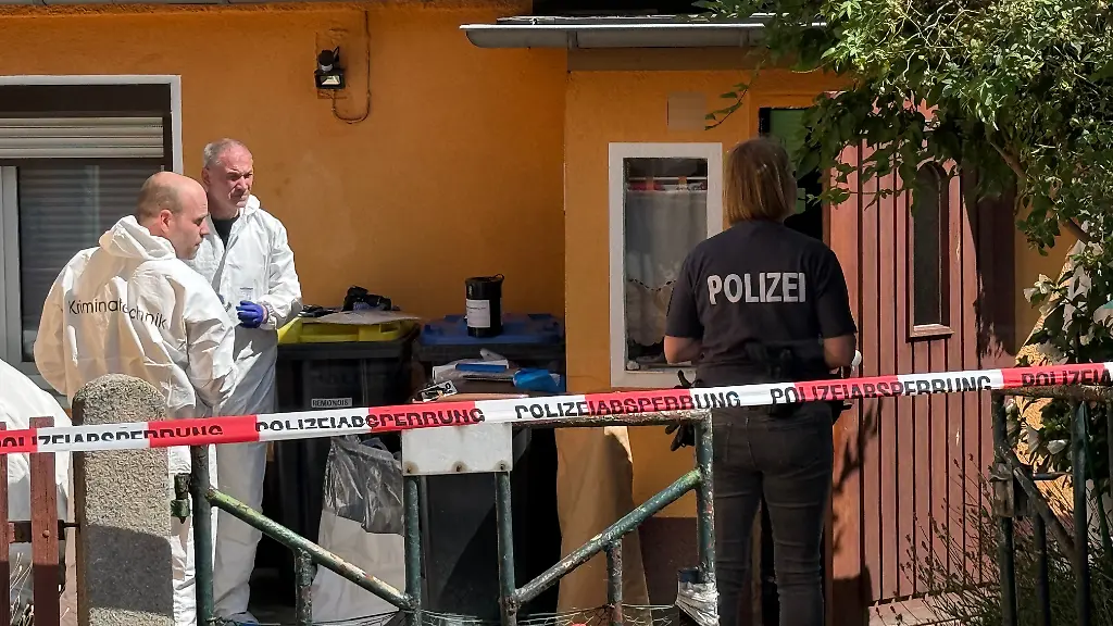 Mitarbeiter-der-Kriminaltechnik-und-Polizei-stehen-vor-einem-Haus-Ermittler-fanden-in-der-Stadt-im-Landkreis-Oberspreewald-Lausitz-die-Leichen-eines-57-Jahre-alten-Mannes-und-einer-45-jaehrigen-Frau-Eine-schwer-verletzte-Person-sei-ins-Krankenhaus-gekommen