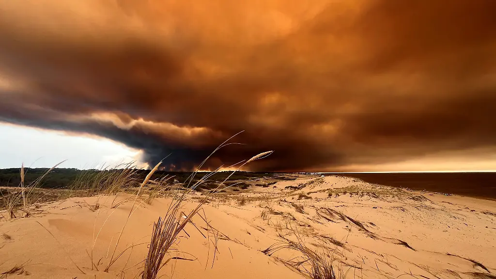 Rauchwolken-von-den-Waldbraenden-suedoestlich-des-Badeortes-Lacanau-Ocean-hinten-r-verdunkeln-den-Himmel-waehrend-sie-ueber-die-Duenen-am-Nordstrand-hinwegziehen