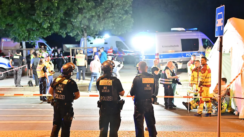 Einsatzkraefte-der-Polizei-und-Rettungskraefte-stehen-im-Grossen-Tiergarten-nach-dem-Abbruch-des-Christopher-Street-Day-CSD-Nachdem-ein-Auto-mehrere-Menschen-am-Rande-des-Christopher-Street-Day-in-Berlin-angefahren-und-verletzt-hat-sucht-die-Polizei-nach-Verdaechtigen-Personen