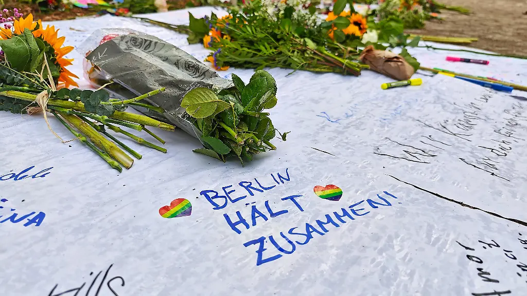 Berlin-Deutschland-Auto-faehrt-bei-CSD-in-Menschenmenge-Am-naechsten-Tag-wurden-am-Tatort-Blumen-niedergelegt-auf-einem-Zettel-steht-die-Botschaft-Berlin-h-lt-zusammen