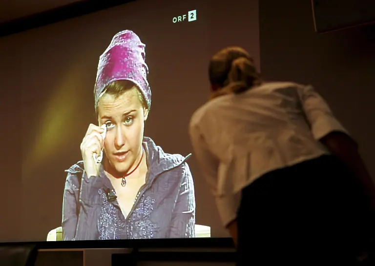 A-woman-watches-the-interview-with-Austrian-kidnapping-victim-Natascha-Kampusch-at-Austrian-television-channel-ORF-in-Vienna-Wednesday-06-September-2006-Publication-of-this-picture-only-in-connection-with-reports-on-the-interview-with-Natascha-Kampusch-on-television-channel-ORF-on-06-September-2006-AND-in-connection-with-reports-on-the-big-public-interest-in-this-interview-The-mentioning-of-the-name-of-the-tv-channel-ORF-is-compulsory-EPA-ROLAND-SCHLAGER-zu-dpa-0313-Kampusch-ueberrascht-mit-ihrem-Interview-Unglaublich-stark-am-07-09