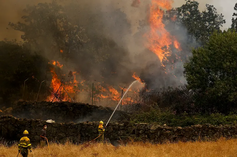 EL-TIEMBLO-SPAIN-JULY-24-Firefighters-and-civillians-attempt-to-extinguish-a-wildfire-as-it-approaches-houses-on-July-24-2026-in-El-Tiemblo-in-Avila-province-Spain-The-Spanish-interior-minister-declared-a-state-of-emergency-as-more-than-11-500-people-were-forced-to-evacuate-their-homes-to-wildfires-across-the-country