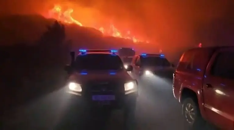 This-screen-grab-taken-from-handout-video-footage-released-on-July-17-2026-by-Spain-s-Military-Emergencies-Unit-UME-shows-vehicles-taking-part-in-the-military-unit-fighting-a-massive-wildfire-through-the-night-in-a-sparsely-populated-part-of-the-Aragon-region-in-the-country-s-northeast-after-the-blaze-doubled-in-size-overnight-to-scorch-over-12-000-hectares