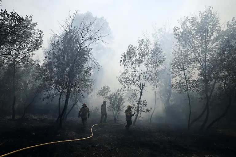 Firefighters-spray-water-in-a-burning-area-as-a-wildfire-flares-up-again-in-Ponteves-southeastern-France-on-July-22-2026-Firefighters-have-managed-to-contain-the-fierce-blaze-that-swept-through-2-550-hectares-in-the-Var-in-less-than-a-day-forcing-the-evacuation-of-around-500-people-and-which-on-July-22-2026-is-still-burning-across-a-vast-mountainside