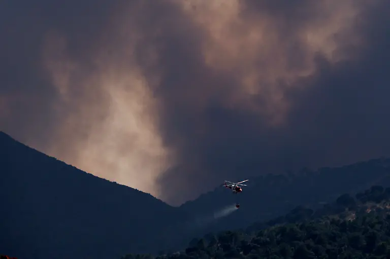 A-firefighting-helicopter-drops-water-on-a-wildfire-near-Robledo-de-Chavela-about-60-kilometres-west-of-Madrid-on-July-27-2026-Spain-faces-two-crucial-days-to-bring-raging-wildfires-under-control-before-weather-conditions-worsen-authorities-said-on-July-27-2026-though-they-were-making-some-progress-and-planned-to-start-returning-evacuees-to-certain-areas-The-fires-in-the-Iberian-country-have-affected-an-area-of-77-000-hectares-190-000-acres-nearly-the-size-of-New-York-City-according-to-the-authorities-Since-the-start-of-the-year-fires-in-Spain-have-ravaged-150-000-hectares-and-killed-13-people