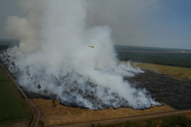 This-aerial-view-taken-from-a-Civil-Security-helicopter-shows-firefighters-working-to-suppress-a-fire-burning-through-a-field-near-Ares-southwestern-France-on-July-28-2026