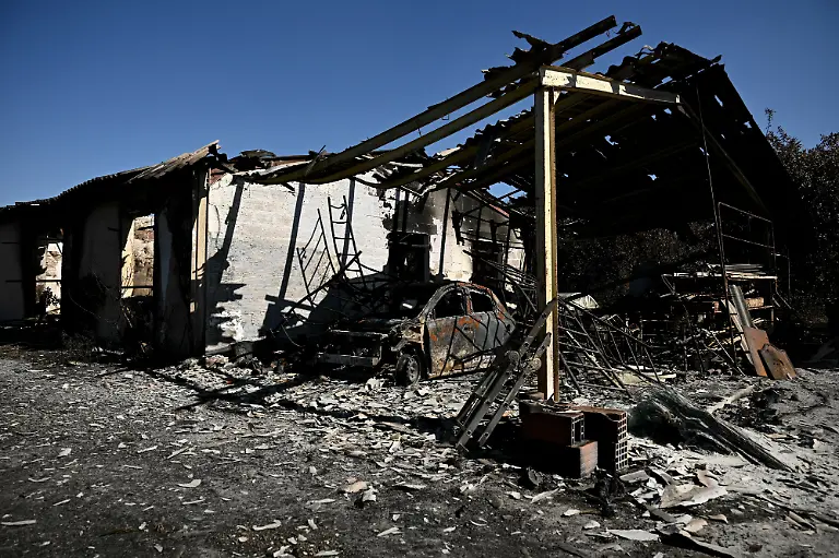 This-photograph-shows-the-building-of-a-painting-company-destroyed-by-a-wildfire-in-a-business-park-in-Biscarrosse-southwestern-France-on-July-28-2026-The-fire-that-broke-out-on-July-23-2026-near-Biscarrosse-in-the-Landes-region-of-southwestern-France-has-been-contained-France-s-President-announced-on-July-27-The-Landes-de-Gascogne-forest-home-to-maritime-pines-and-a-vital-lung-for-the-timber-industry-has-seen-42-000-hectares-burn-near-Bordeaux-Forests-are-catching-fire-all-the-more-easily-because-European-vegetation-and-soils-have-been-very-dry-for-monthsa-drought-exacerbated-by-climate-change-and-recent-exceptional-heatwaves