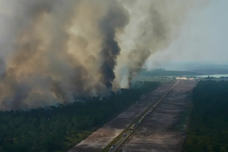This-aerial-view-taken-from-a-Civil-Security-helicopter-shows-firefighting-vehicles-lined-up-along-a-road-to-suppress-fires-near-Ares-southwestern-France-on-July-28-2026